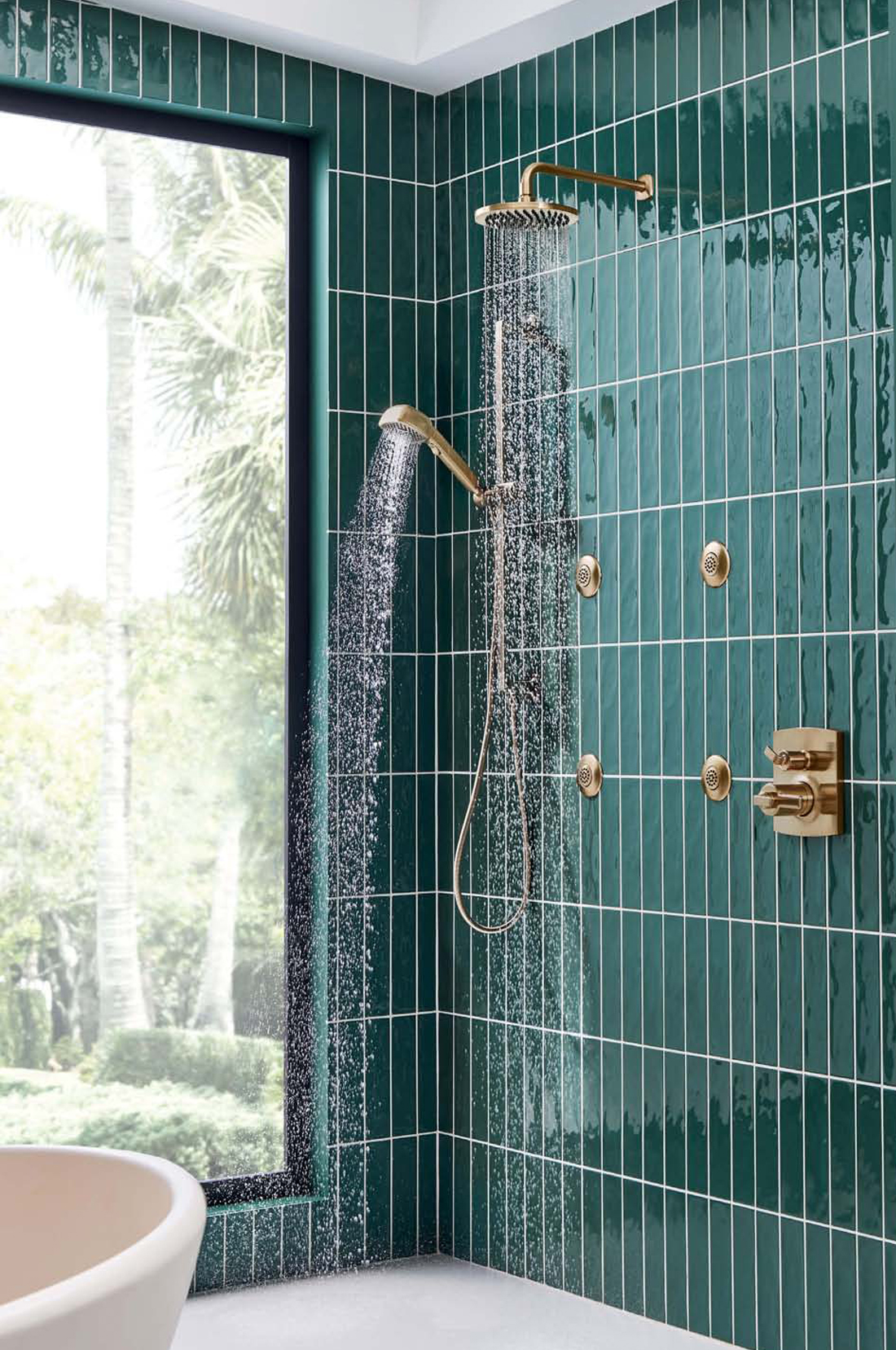 Gold Shower accessories with green tiles garden view